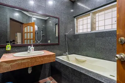 a bathroom with a sink and a tub and a mirror at Bangsar Villa for groups, event space and family fun in Kuala Lumpur