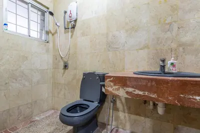 a bathroom with a toilet and a sink at Bangsar Villa for groups, event space and family fun in Kuala Lumpur