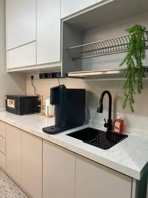 a kitchen with a sink and a microwave at Sunset View at Modern Home in Kuala Lumpur