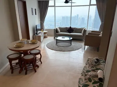 a living room with a table and chairs and a large window at vortex klcc apartment by Dream NIGHT in Kuala Lumpur