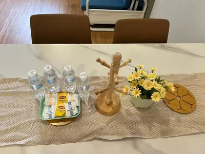 a table with bottles of water and a figurine and flowers at KL Chambers Suites BY Fortune in Kuala Lumpur