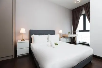 a bedroom with a large white bed with two lamps at Velocity Residence Suites By PSM in Kuala Lumpur