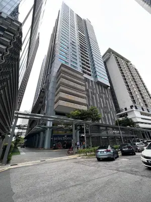 a parking lot with cars parked in front of a tall building at 12mins walk to KLCC in Kuala Lumpur