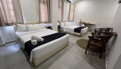a hotel room with two beds and a chair at Cojoy Hotel @ Chinatown in Kuala Lumpur
