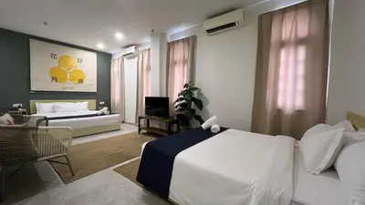 a bedroom with a bed and a living room at Cojoy Hotel @ Chinatown in Kuala Lumpur