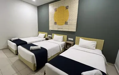 a room with three beds and a painting on the wall at Cojoy Hotel @ Chinatown in Kuala Lumpur