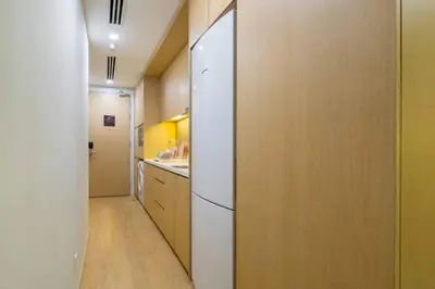 a kitchen with a white refrigerator in a room at THE APARTMENT at 188 SUITES KLCC in Kuala Lumpur