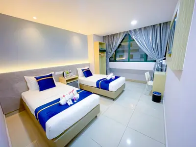 a hotel room with two beds with dolls on them at StarQ Hotel Kuala Lumpur in Kuala Lumpur