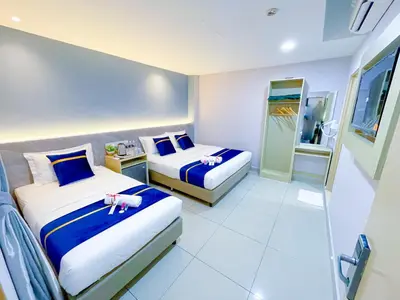 a hotel room with two beds with dolls on them at StarQ Hotel Kuala Lumpur in Kuala Lumpur