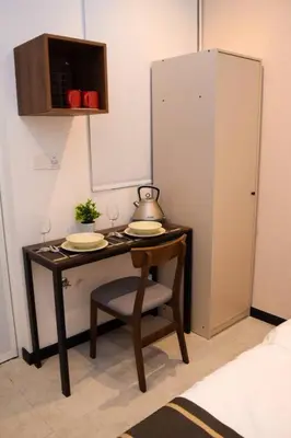 a small table with a chair in a room at Neu Suites Studio Room - 3km to KLCC, 8 mins walk to LRT in Kuala Lumpur