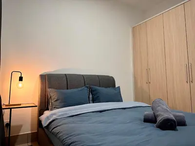 a bedroom with a bed with a wooden cabinet at Razak City Residences, Sungai Besi by Rverse Suite in Kuala Lumpur