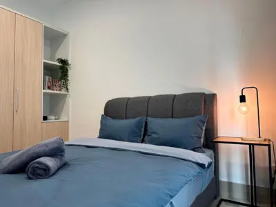 a bedroom with a bed with blue pillows and a lamp at Razak City Residences, Sungai Besi by Rverse Suite in Kuala Lumpur