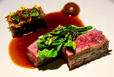 a plate of food with a piece of cake and sauce at 163 SUPER KING BED STUDIO near Petronas Twin Tower KLCC KL Convention Center by Zen Glo in Kuala Lumpur