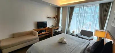 a hotel room with a bed and a couch and a television at 163 SUPER KING BED STUDIO near Petronas Twin Tower KLCC KL Convention Center by Zen Glo in Kuala Lumpur