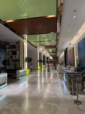a lobby of a building with people sitting at tables at The Platinum KLCC by Skyline in Kuala Lumpur
