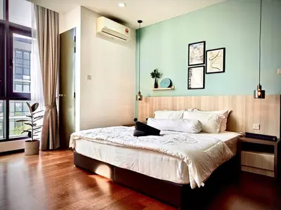 a bedroom with a large bed with a blue wall at Premium Cozy Studio Near Mid Valley in Kuala Lumpur