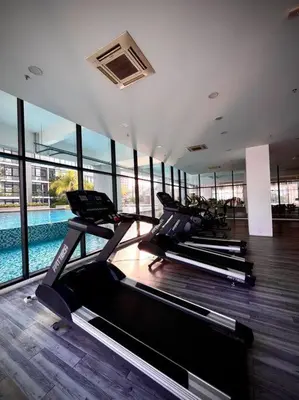a gym with several treadmills and a swimming pool at Premium Cozy Studio Near Mid Valley in Kuala Lumpur