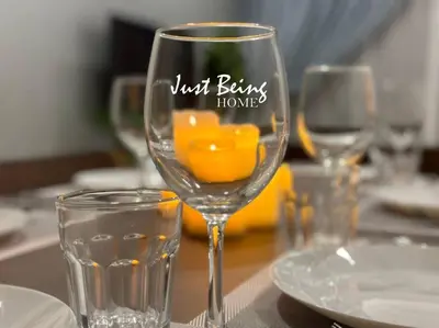 a wine glass with just burns home written on it on a table at Just Being Home 5pax 1BR/1BA 1Queen/1Single/1Sofa in Kuala Lumpur