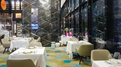 a dining room with white tables and chairs at KLCC Suites at Platinum in Kuala Lumpur