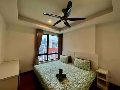 a bedroom with a bed with a ceiling fan and a window at Casa Residency Service Apartment By Moonlight in Kuala Lumpur