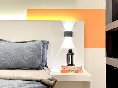 a bedroom with a bed and a lamp on a night stand at The Latrobe - Bangsar Trade Centre in Kuala Lumpur