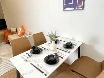 a white table with chairs and plates and utensils at The Latrobe - Bangsar Trade Centre in Kuala Lumpur