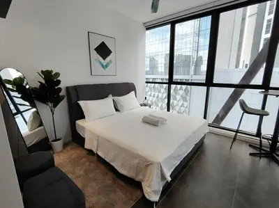 a bedroom with a white bed and a large window at Scarletz Suites KLCC by KAN's in Kuala Lumpur