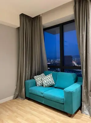 a blue couch in a room with a large window at D’ Majestic Place by Bimbee in Kuala Lumpur