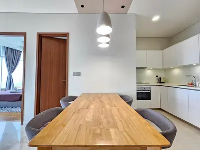 a kitchen and dining room with a wooden table and chairs at Sky Suites & Residence KLCC Kuala Lumpur in Kuala Lumpur