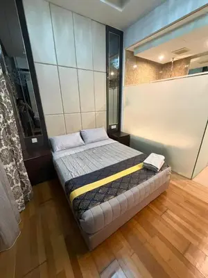 a bedroom with a bed in a room with wood floors at Dorsett Bukit Bintang in Kuala Lumpur