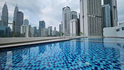 a large swimming pool in a city with tall buildings at Balcony KLCC View Kampung Baru Luxurious in Kuala Lumpur