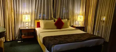 a hotel room with a bed with two tables and two lamps at Raymond Suites at Times Square kuala Lumpur in Kuala Lumpur