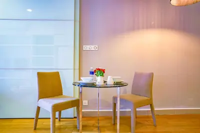 a table with two chairs and a table with flowers on it at SKYWARD SUITES at Platinum KLCC in Kuala Lumpur