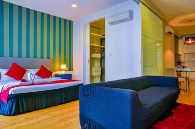 a bedroom with two beds and a couch in it at SKYWARD SUITES at Platinum KLCC in Kuala Lumpur