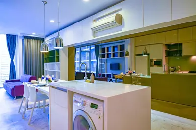 a kitchen and living room with a washer at SKYWARD SUITES at Platinum KLCC in Kuala Lumpur