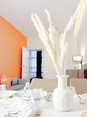 a white vase with white feathers on a table at The Lonsdale - Bangsar Trade Centre in Kuala Lumpur