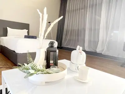 a white table with a bottle on top of it at The Bourke - Bangsar Trade Centre in Kuala Lumpur
