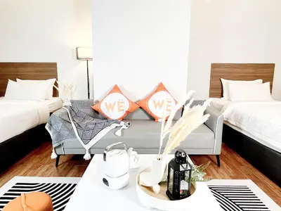 a living room with two beds and a couch at The Collins - Bangsar Trade Centre in Kuala Lumpur