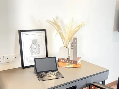 a desk with a laptop computer and books on it at The Collins - Bangsar Trade Centre in Kuala Lumpur