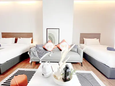 two beds in a room with a couch and a table at The Collins - Bangsar Trade Centre in Kuala Lumpur