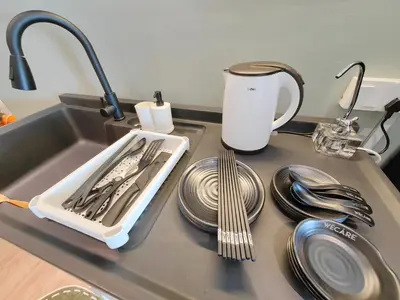 a kitchen counter with a tray of utensils and plates at The Tranquil - Bangsar Trade Centre in Kuala Lumpur