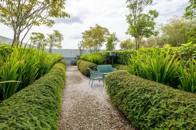 a garden with a table and some bushes at UNA Residence By Feel Home Malaysia opposite Sunway Velocity Mall in Kuala Lumpur