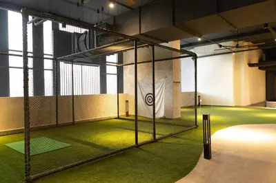 a gym with a batting cage with green grass at Societe Hartamas in Kuala Lumpur