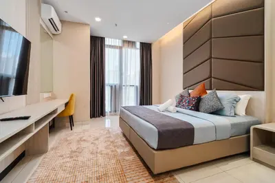 a hotel room with a bed and a flat screen tv at Societe Hartamas in Kuala Lumpur
