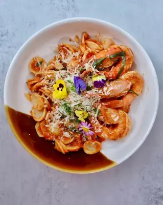 a bowl of shrimp with sauce and flowers on it at Societe Hartamas in Kuala Lumpur