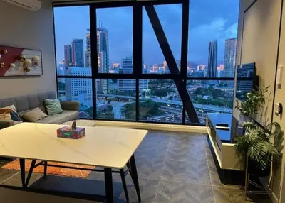 a living room with a table and a large window at Scarletz Suites Klcc by Signature Apartment in Kuala Lumpur
