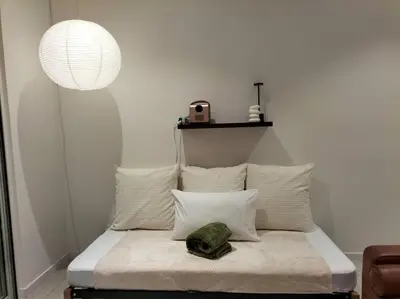 a bedroom with a bed with a lamp and pillows at Quill Residence by Cozy Simple Stay in Kuala Lumpur