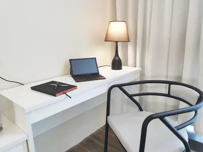 a white desk with a laptop and a chair at The Sandstone - Bangsar Trade Centre in Kuala Lumpur