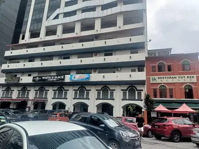 a parking lot with cars parked in front of a tall building at James' Studio unit Maison 101 at Heritage Row, Kuala Lumpur in Kuala Lumpur
