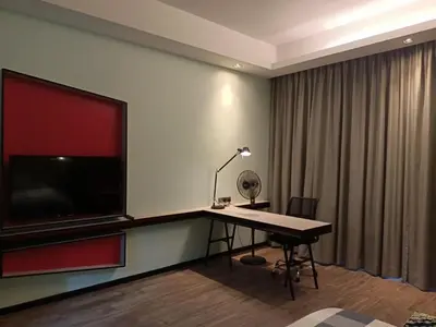a room with a desk with a large television on the wall at James' Studio unit Maison 101 at Heritage Row, Kuala Lumpur in Kuala Lumpur